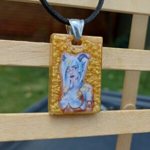 A white succubus with a gold background on a black faux cord necklace.
