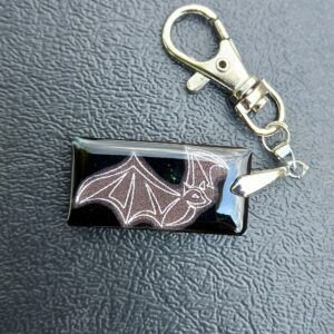 A black keyring with the image of a bat.